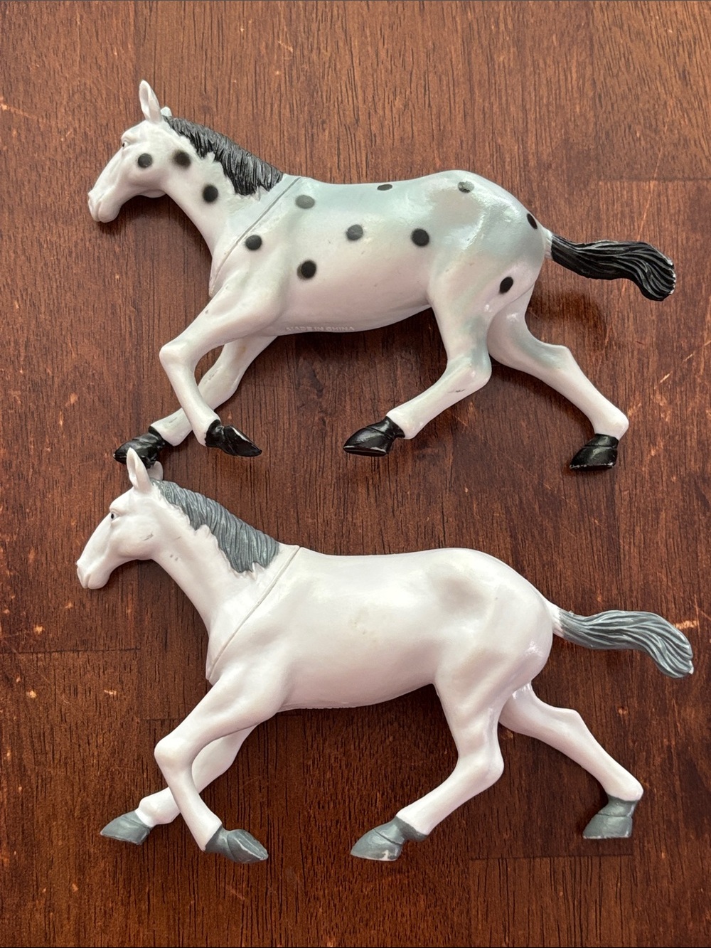 Toy horses a white and black spotted Appaloosa stallion & a white/gray trotting